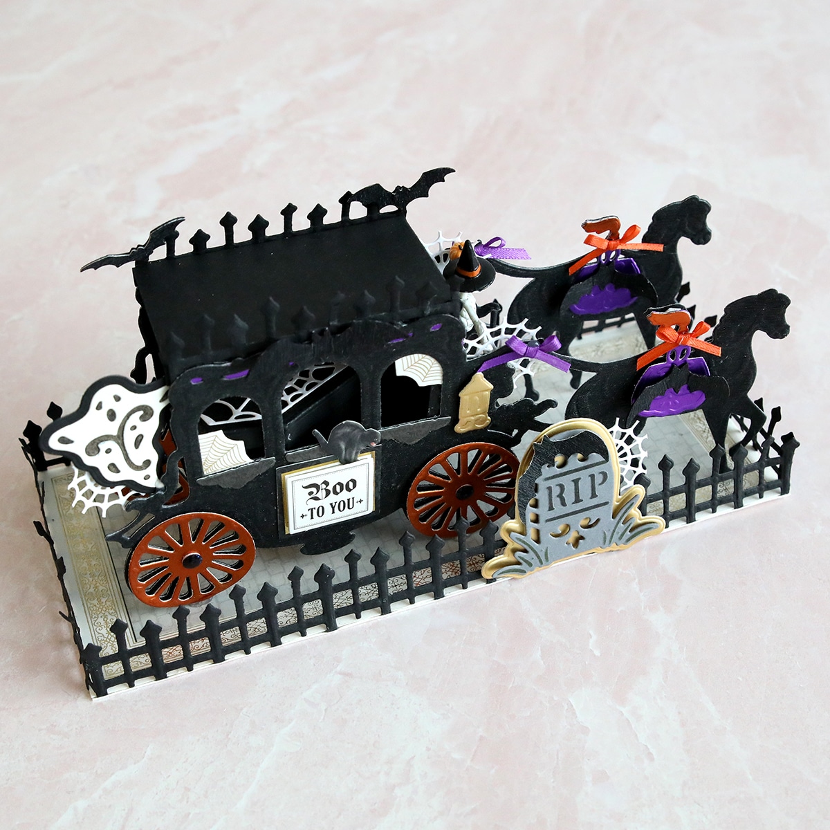 A pop up halloween carriage with bats and skeletons.