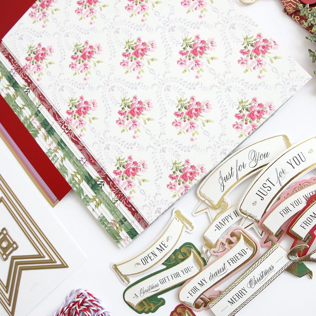 A collection of christmas papers and decorations on a table.