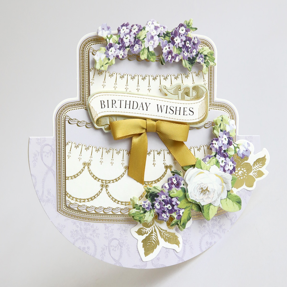 A card with a cake and flowers on it.
