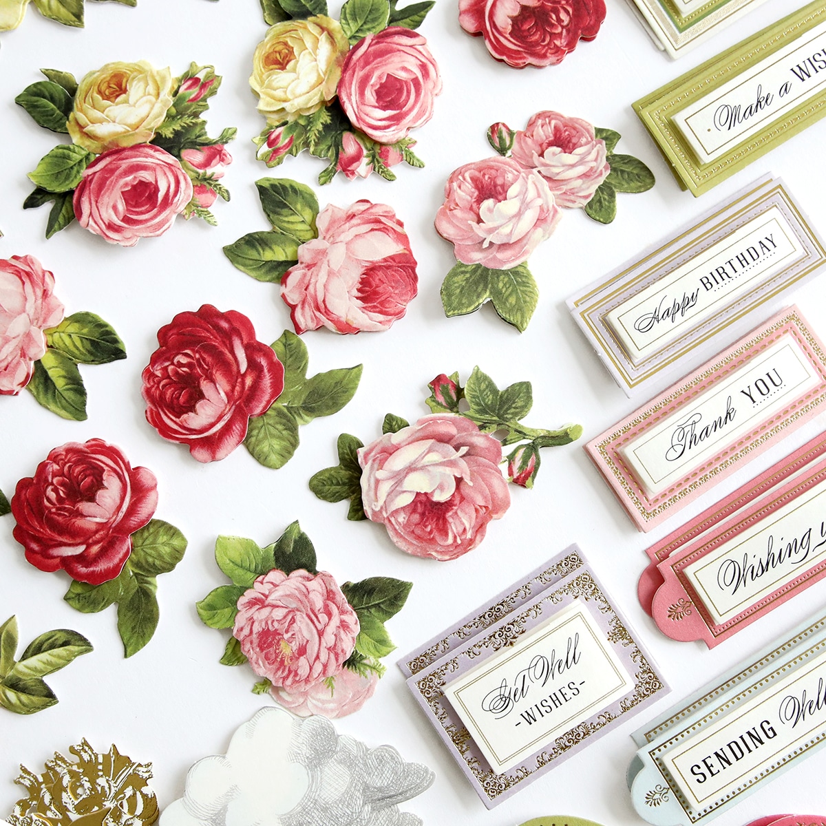 A collection of paper roses and tags on a white surface.