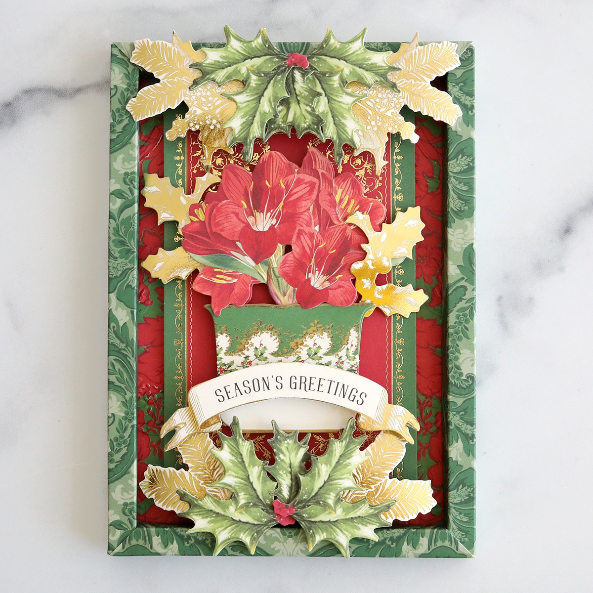 A christmas card with holly leaves and holly berries.