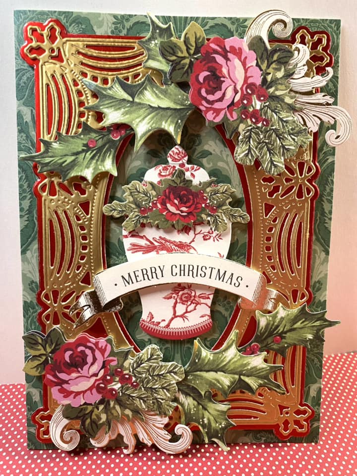 A christmas card with holly and roses on it.