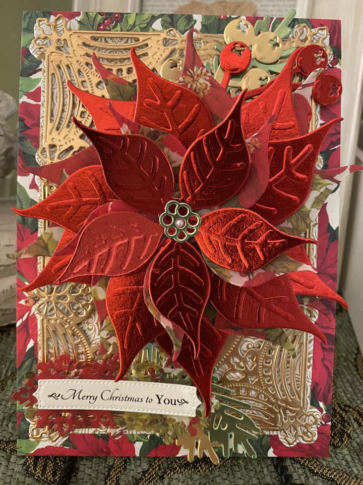 A christmas card with a red poinsettia on it.