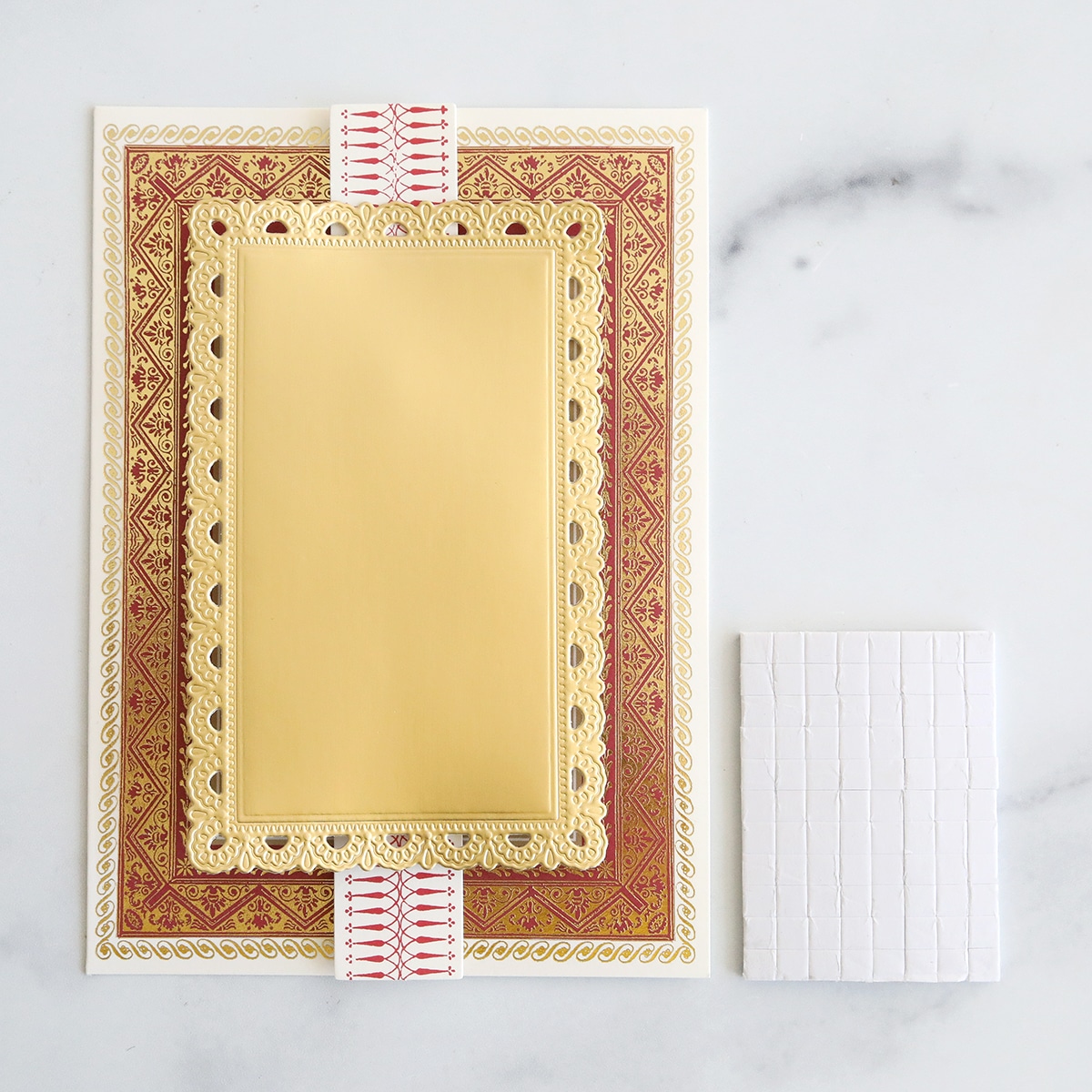 A card with a gold frame and a piece of paper.