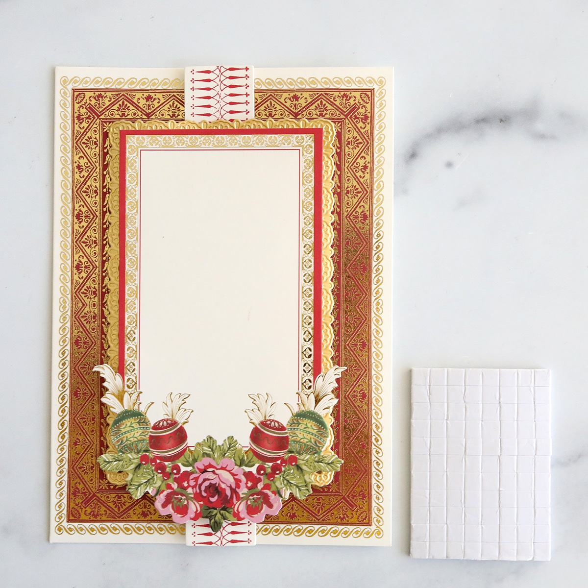 A christmas card with a red and gold frame.
