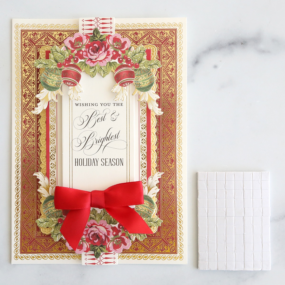 A card with a red bow and a red ribbon.