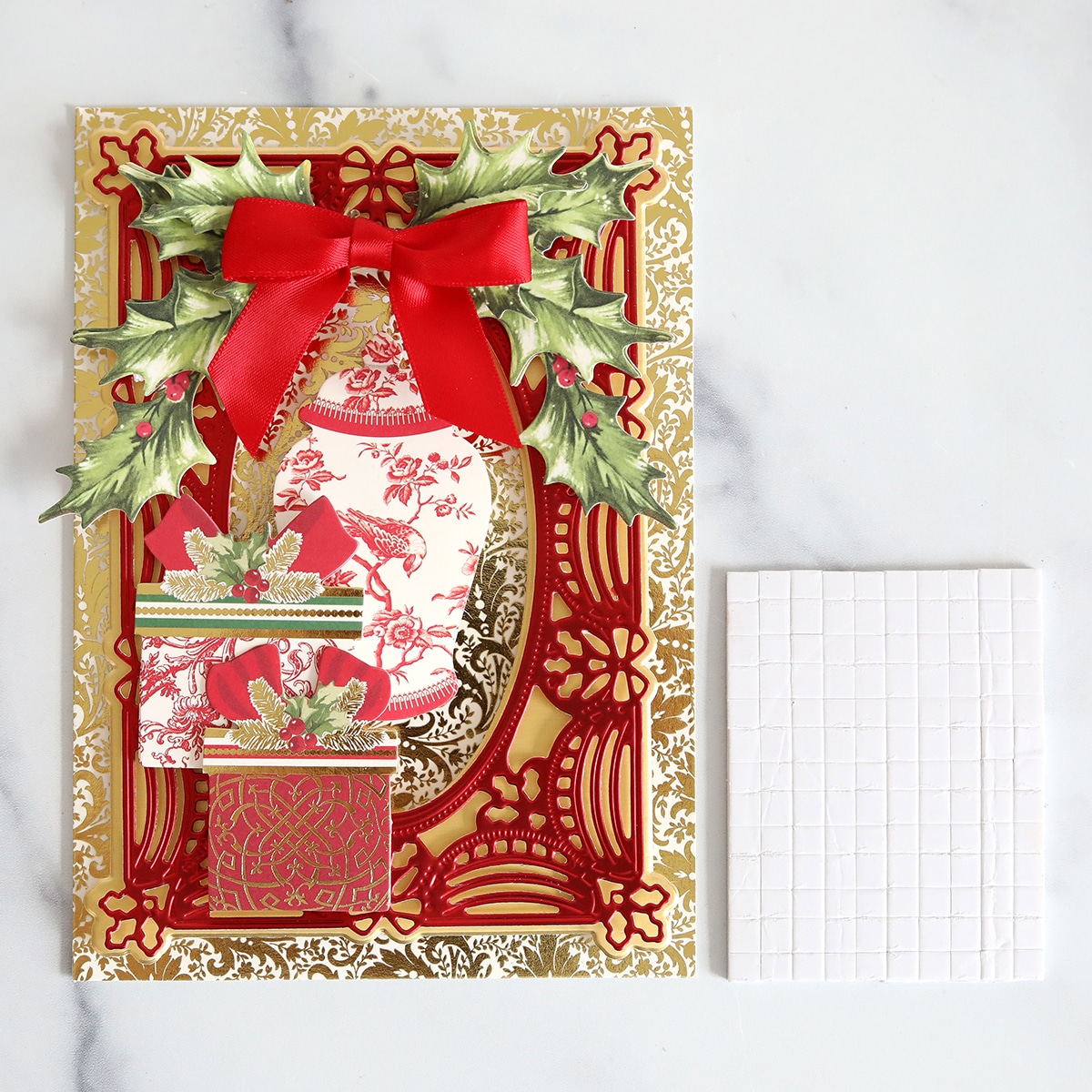 A christmas card with holly and bows on it.