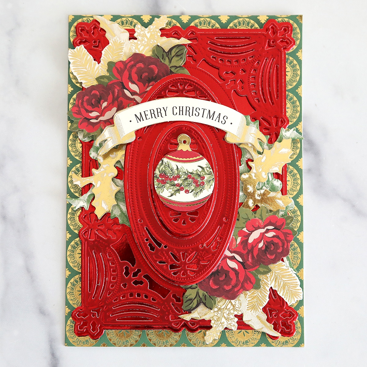 A christmas card with a red ornament and roses.