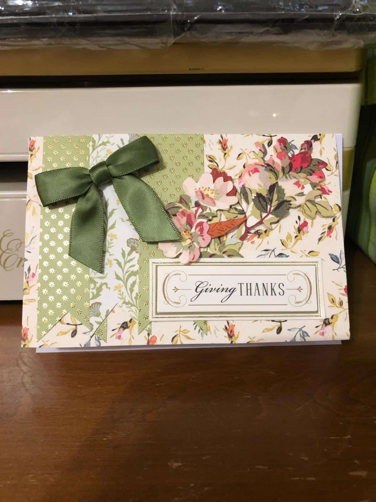 A thank you card with a green bow on it.